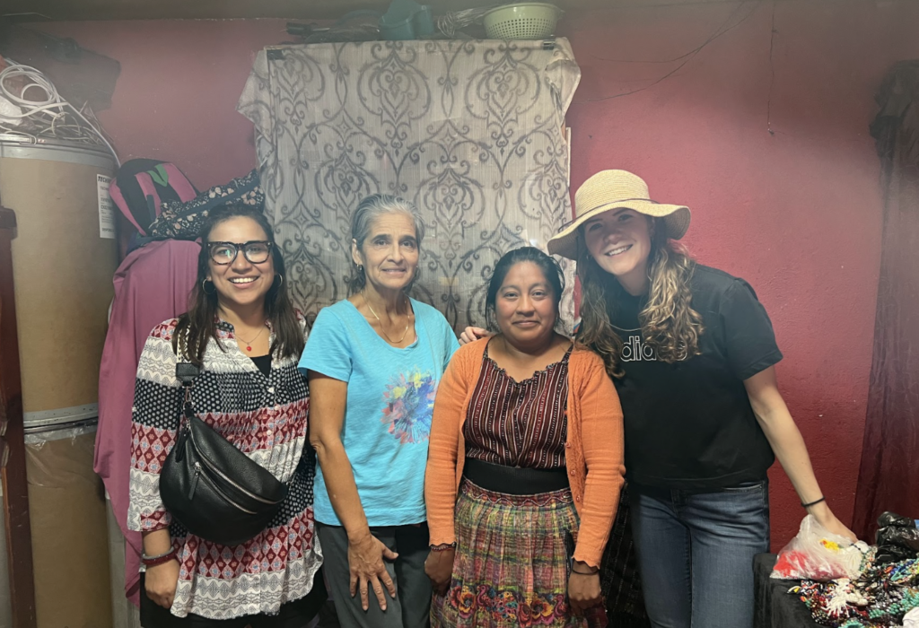 A Guatemalan women stands with tourists in her home.
