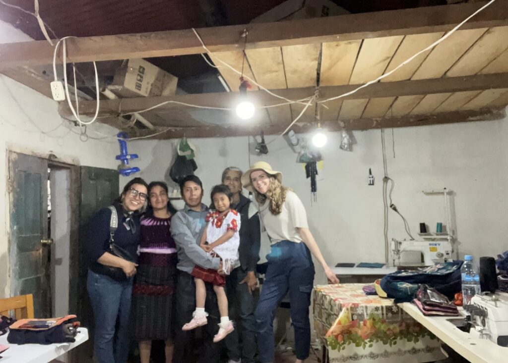 A Guatemalan family poses with tourists in their workshop.