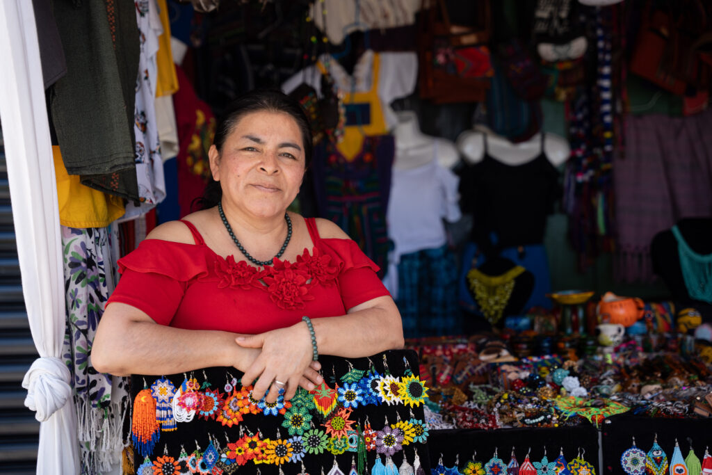 A Guatemalan woman sells jewelry at an outdoor market.